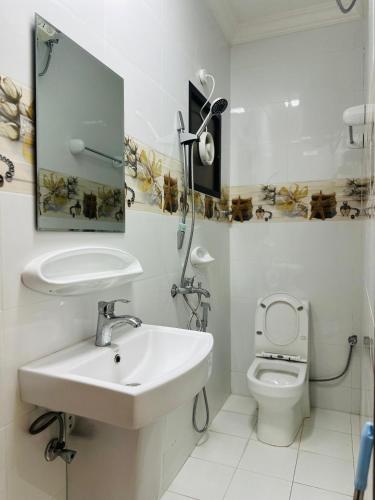 a white bathroom with a sink and a toilet at العربي للشقق المفروشة in Salalah