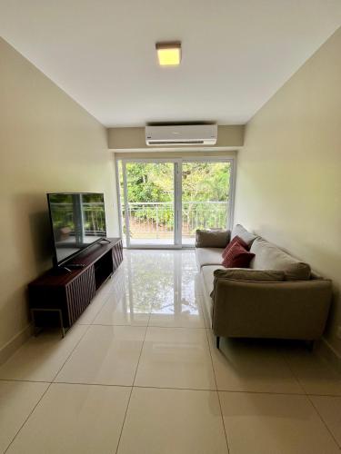 a living room with a couch and a flat screen tv at Refugio Caribeño in Puerto Limón