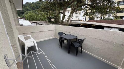 a patio with two chairs and a table on a balcony at Suíte 14 • Praia das Pitangueiras in Guarujá