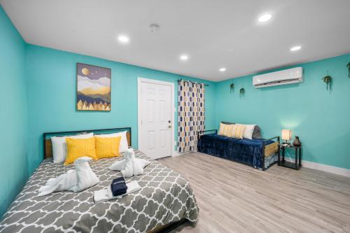 a bedroom with blue walls and a bed and a couch at West U Studio, Near Med Center, Stadiums & Zoo in Houston