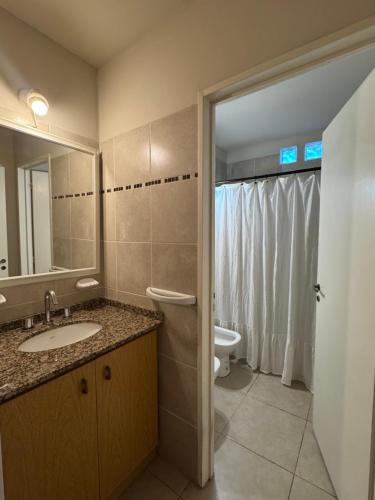 a bathroom with a sink and a toilet and a mirror at Duplex premium in La Porteña
