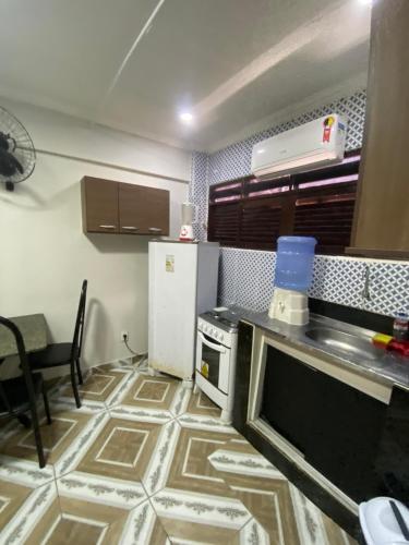a small kitchen with a stove and a refrigerator at Pousada Atlântico tambaú praia in João Pessoa