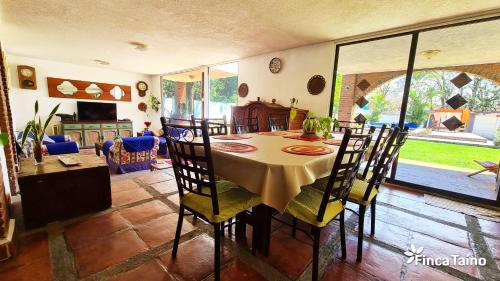 a dining room with a table and chairs at Finca Taino. Hermosa casa con alberca in Jiutepec