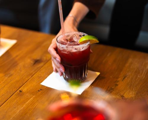 a person holding a drink with a lime on a table at Kansas City Marriott Downtown in Kansas City