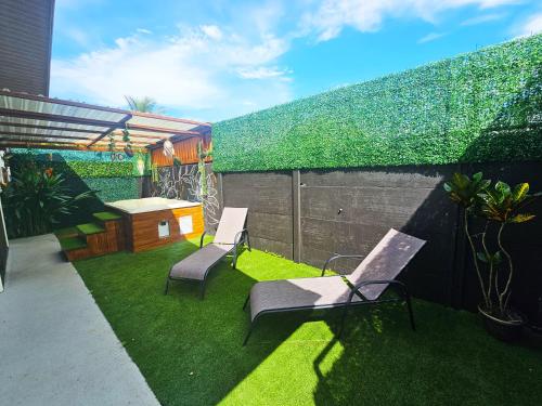 a backyard with two chairs and a fence with grass at Hormiga's Houses in Fortuna