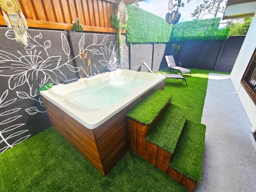 a bathroom with a bath tub with green grass at Hormiga's Houses in Fortuna