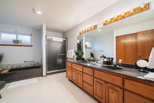 a bathroom with a sink and a large mirror at 14 Person Adventure Oasis with Hotub in Wenatchee