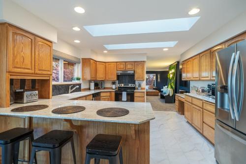 a large kitchen with wooden cabinets and a refrigerator at 14 Person Adventure Oasis with Hotub in Wenatchee
