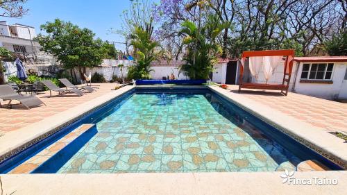 a swimming pool with a tile floor at Finca Taino. Hermosa casa con alberca in Jiutepec
