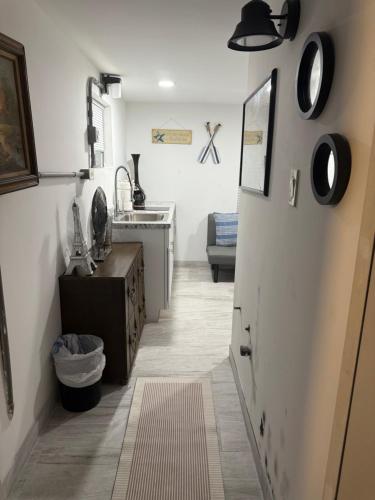 a kitchen with a hallway with a door and a sink at Seabreeze Cottage in Lantana
