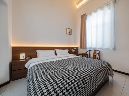 a bedroom with a bed with a black and white comforter at JOYSEA HUT in Yantai