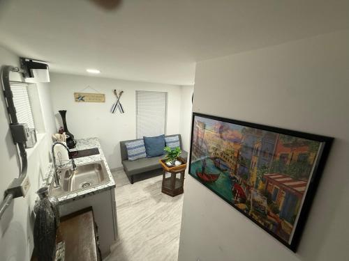 a living room with a sink and a painting on the wall at Seabreeze Cottage in Lantana