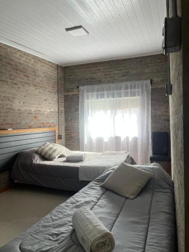 two beds in a bedroom with a window at Chacra LANATIVA in Poblado Echeverry