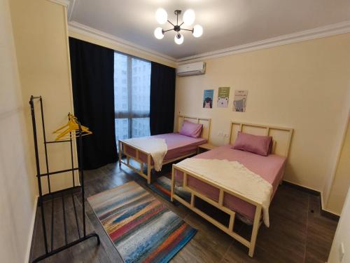 a room with two beds and a window at Comfort Plaza A in Cairo