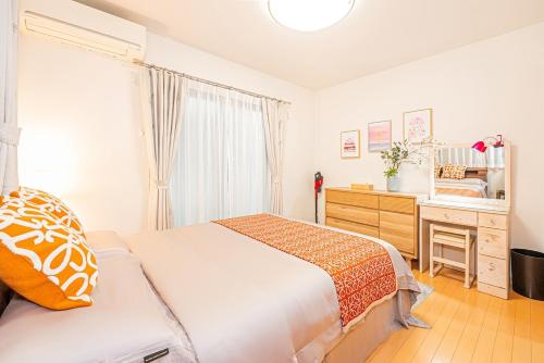 a bedroom with a bed and a dresser and a mirror at Anzu 4 Bed rooms Villa 5 minutes walk from Keise line Edogawa station in Tokyo