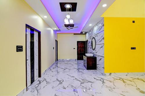 a lobby with a marble floor and a yellow wall at Hotel O SRI SAI PALACE in Bārang
