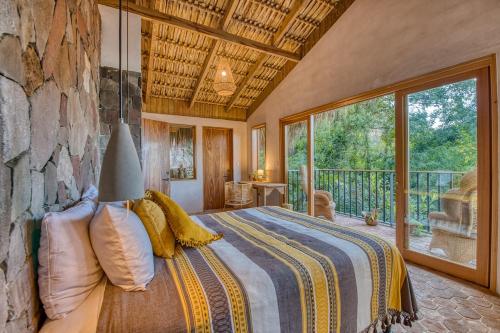 a bedroom with a bed and a large window at NEW! Jacuzzi, lake-access luxury in San Marcos La Laguna