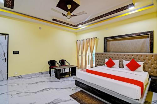 a bedroom with a bed and a table and chairs at Hotel O SRI SAI PALACE in Bārang