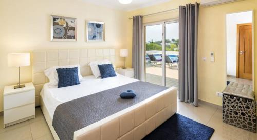 a bedroom with a large bed and a balcony at Villa Povo Do Burro, Beautiful And Elegant Villa, Few Minutes Walk To Resort in Carvoeiro