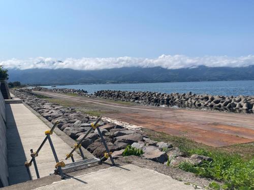 a group of rocks on the side of a body of water at 佐渡島 築120年の古民家一棟貸切 河崎浪漫館 囲炉裏体験 檜風呂-蔵サウナ完備 in Sado