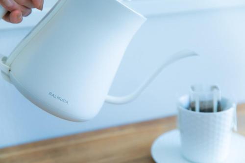 a person is using a blender on a counter at Marina blue zushi in Zushi