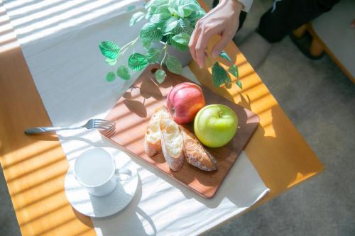 a table with a cutting board with apples and croissants at Marina blue zushi in Zushi