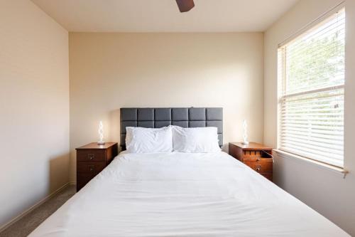 a bedroom with a large white bed and a window at Gorgeous 2story Home with 4 bedrooms in Buda