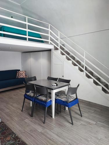 una sala da pranzo con tavolo, sedie e scale di La Perla del Borgo Casa Vener a Vieste