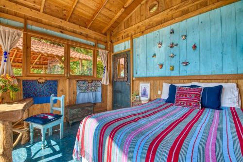 a bedroom with a bed and a wooden wall at Magical lakeview Casita, swim dock, sauna, kitchen in San Marcos La Laguna