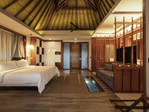 a bedroom with a bed and a couch at Tahiti Lagoon Resort in Punaauia