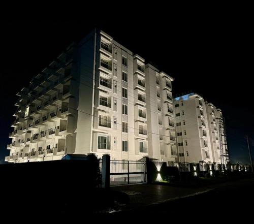 Un grand bâtiment blanc est éclairé la nuit. dans l'établissement One bed comfortable luxury apartment, à Dargai