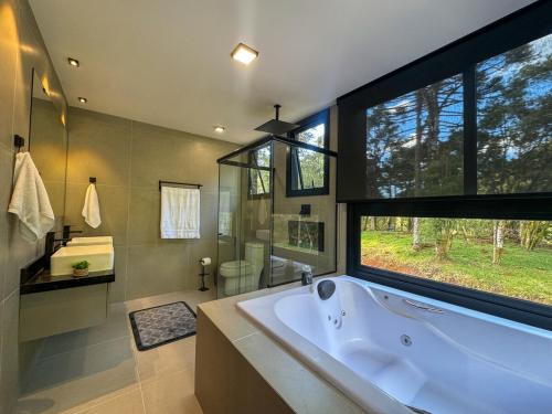 Un baño con bañera y una gran ventana. en Casa Despertar na Montanha Urubici, en Urubici