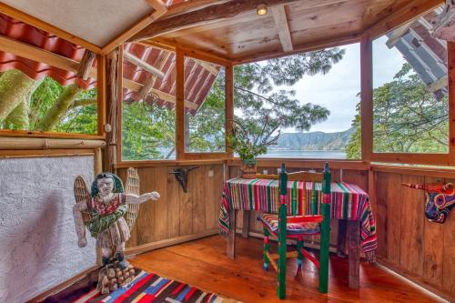 a room with a table in a cabin at Lake view paradise- waterfall, swim dock, kitchen in San Marcos La Laguna