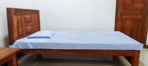 a bed with a wooden frame in a room at Igloo Tourist Homestay Anuradhapura in Anuradhapura