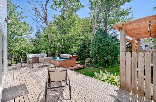 a wooden deck with a grill and chairs on it at The Montgomery in Cavendish