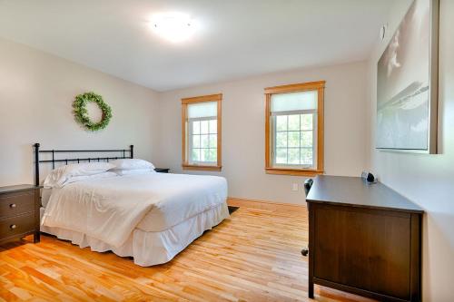 a bedroom with a bed and a dresser and windows at The Montgomery in Cavendish