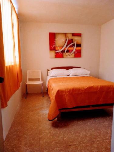 a bedroom with a bed and a painting on the wall at Casa SUR in Colonia de Venado
