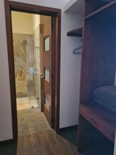 ein Badezimmer mit ebenerdiger Dusche und Glastür in der Unterkunft Hotel Las Violetas in Zacatlán