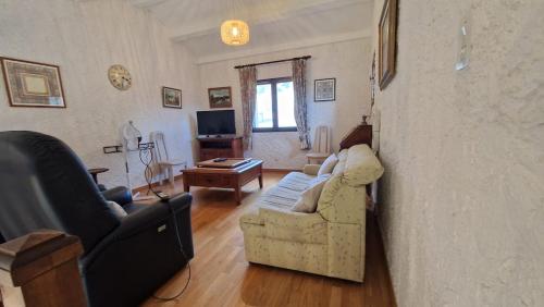 a living room with a couch and a tv at Villa Verdon en Provence - Vue sur le Lac d'Esparron sur Verdon in Esparron-de-Verdon