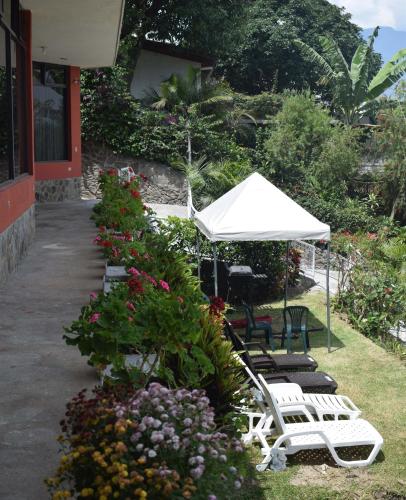 a group of chairs and an umbrella and flowers at Casa Gaspar on Lake Atitlán in San Antonio Palopó