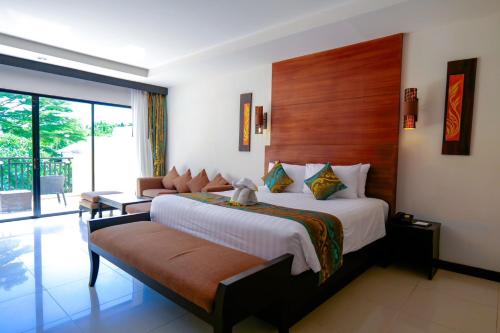 una camera con un grande letto e un balcone di Horizon Karon Beach Resort & Spa a Karon Beach