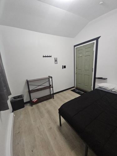 a bedroom with a bed and a green door at Cozy Camo Cottage #8 in Houston