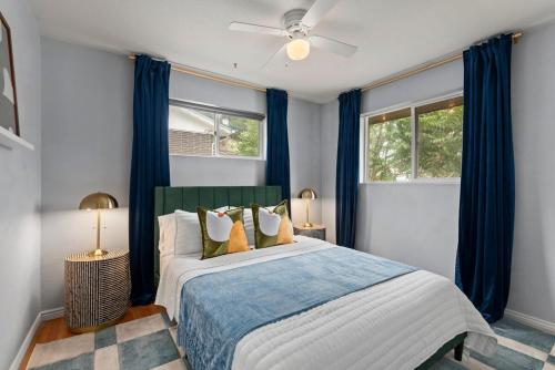 a bedroom with a large bed with blue curtains at Cozy 5BR - Outdoor Theater, Fire Pit, Games in Westminster