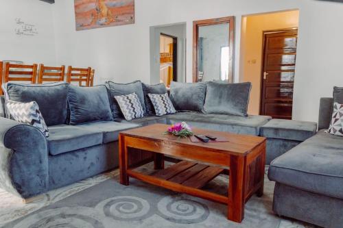 a living room with a blue couch and a coffee table at jahazi homes -watamu in Watamu