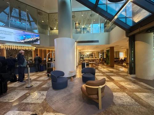 a lobby with couches and chairs in a building at Flat 805 - Avenida Ibirapuera, Moema - São Paulo in Sao Paulo