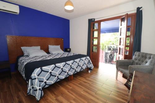 a bedroom with a bed and a couch and a window at Hotel Casa Frida in Cuernavaca