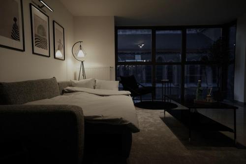 a bedroom with a bed and a couch and a window at Chic Loft Facing Neo-Gothic Church in Ghent