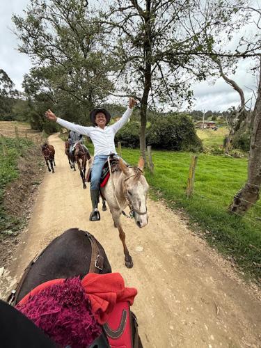 a young girl riding a horse on a dirt road at Villa Rebequita in Villapinzón