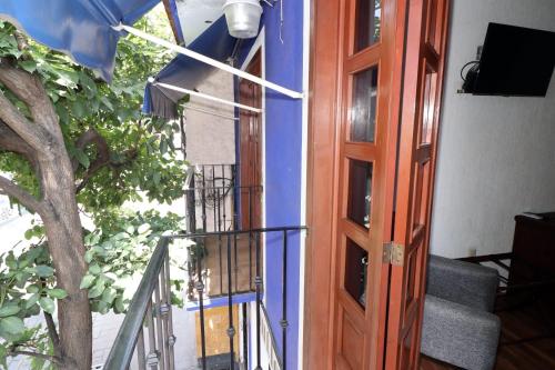 a door to a building with a staircase next to a tree at Hotel Casa Frida in Cuernavaca