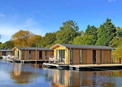 a row of wooden lodges on a body of water at York Marina in Naburn